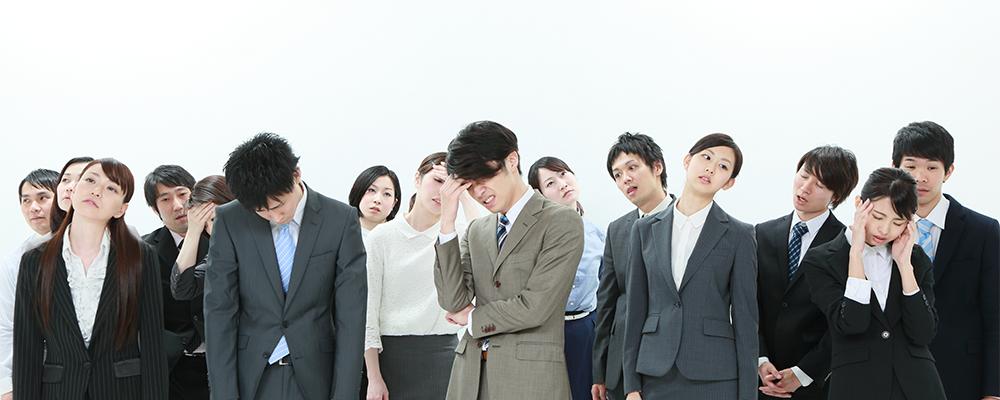 うなだれるビジネスパーソンたち