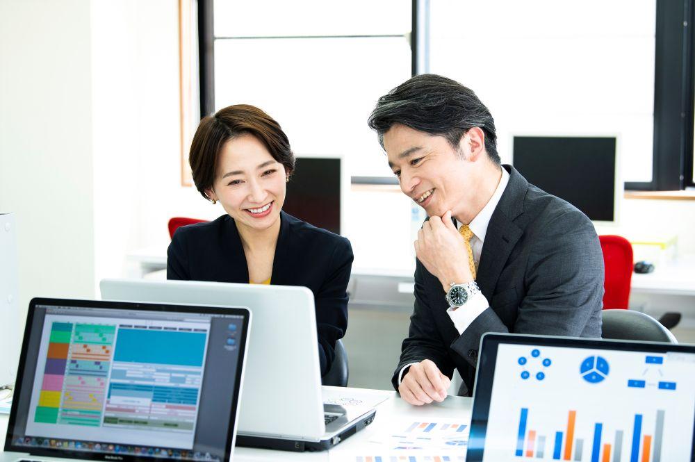 データを見ながら話すビジネスパーソン